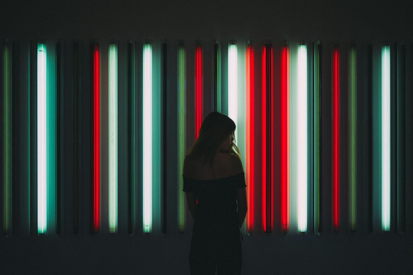 a person standing in front of neon lights